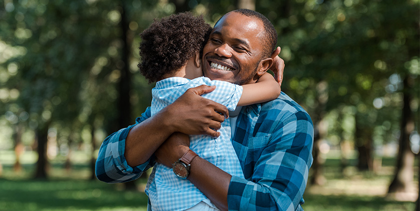 African american father smiling and hugging his child